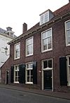 Pand, deel uitmakend van rij aaneengeschakelde 19e-eeuwse huizen, in bocht van de singel gelegen onder een rechte daklijst. Harmonische raamverdeling met luiken