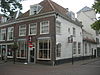Huis met lijstgevel. Zijgevel gepleisterd en gewit