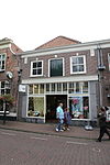 Huis met lijstgevel met leeuwen, maskers en koppen boven de vensters