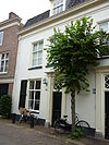 Woonhuis met gepleisterde kroonlijstgevel en voordeur met zijpilasters en bekroning