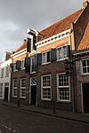 Amersfoort.Coninckstraat.15.JPG -  Logies De Tabaksplant - Huis met gevel uitgevoerd in baksteen. Hijskap met luiken. Strekken boven de deuren en ramen 