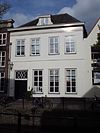 Huis met gepleisterde gevel met rechte kroonlijst