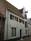 Pakhuis met gemetselde dakkapel, van hijsbalk voorzien, de daklijst doorsnijdend
