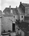 Pand, deel uitmakend van groep van drie woningen. Boven de tweede verdieping een overstekende op korbelen rustende rand