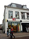 Pand, een geheel met nr 88. Huis met rechte kroonlijst met tandingen. Dak door twee schoorstenen bekroond. Diep doorlopend terzijde van de Joriskerk, langs de Groenmarkt gepleisterd