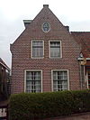 Pand met lage gevel, kleine roeden, zadeldak in topgevels eindigend