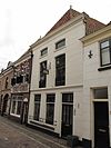 Pand met schilddak, dat aan de achterzijde aansluit tegen een puntgevel met ontlastingsbogen