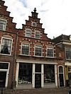 Pand met trapgevel van het Zuidhollandse type met geprofileerde waterlijsten, geblokte vensternissen met afgeschuinde dagkanten en vlechtwerk in de boogtrommels, alsmede versierde toppilasters op ma