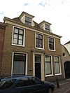 Pand met verdieping en hoog schilddak met topschoorstenen, haaks op de straat