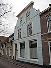 Pand met gepleisterde en boven ingezwenkte lijstgevel met stucversieringen