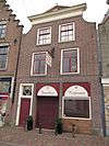 Pand met schilddaken gevel met ingezwenkte zijkanten en houten kroonlijst