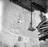 Interieur van ronde stenen korenmolen met wapenschild