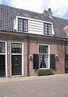 Pand met gepleisterde lage gevel met rechte kroonlijst