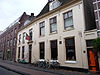 Combinatie van twee vrijwel gelijktijdig gebouwde huizen met twee bouwlagen, een zadeldak evenwijdig aan de straat en kelders