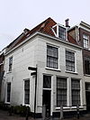 Hoekpand met twee bouwlagen en een kap loodrecht op de straat