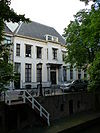 Statig gepleisterd herenhuis met vooruitspringende middenpartij op zuilen