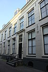 Pand met gepleisterde langgerekte gevel met rechte kroonlijst