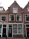 Pand, bestaande uit twee bouwlagen met kap, loodrecht op de straat, en een kleine kelder met tongewelf