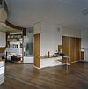 Interieur, overzicht woonkamer- toegangsdeur naar de hal, klok aan de muur, muurtafel, vaste kastenwand en verlaagd plafond (werkruimte) - Utrecht - 20340453 - RCE -  Woonhuis Architect Sybold Van Ravesteyn: Interieur, overzicht woonkamer: toegangsdeur naar de hal, klok aan de muur, muurtafel, vaste kastenwand en verlaagd plafond (werkruimte) 