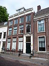 Pand met gevel met rechte consoles kroonlijst, versierde deurpartij, gesmeed ijzeren hek