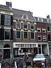 Pand met lijstgevel met hoog zadeldak, boven de vensters bogen met natuurstenen blokken