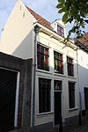 Huis met twee bouwlagen, een kap met de nok evenwijdig aan de straat en een kelder