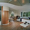 Interieur, overzicht woonkamer richting de eethoek en de zithoek. Links een gebogen vaste inbouwkast met bovenkastje - Utrecht - 20340459 - RCE -  Woonhuis Architect Sybold Van Ravesteyn: Interieur, overzicht woonkamer richting de eethoek en de zithoek. Links een gebogen vaste inbouwkast met bovenkastje 