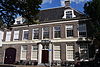 Statig herenhuis met rechte kroonlijst, 8 ramen breed, deels verbouwd tot garage