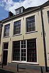 Huis bestaande uit twee bouwlagen met kap loodrecht op de straat en een kelder met tongewelf