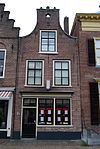 Huis met tuitgevel met bekronende ballen