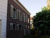 Aansluitend bij Buitenlandpoort 1 een eenvoudige lijstgevel voor huis met schilddak