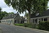 Serie woningen onder een lang zadeldak en rechte daklijst, gepleisterd