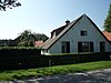 Boerderij, gepleisterd bakstenen gebouw onder rieten zadeldak met topgevel aan de voorzijde en afgewolfd aan de achterkant