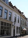 Huis met gepleisterde lijstgevel met getrapgevelde scheidsmuren