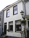 Huis met gepleisterde gevel met hoog tentdak