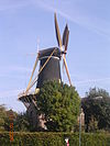 De Windhond (Woerden) - Zelfgemaakte foto van de Windhond, de molen in het centrum van Woerden. Foto gemaakt op donderdag 13 oktober 2005. Het was mooi weer, de molen werkte, maar stond helaas met de wieken in de richting van de singel/het station, zodat het moeilijk was een mooie foto te maken: ik moest teveel onder de helling van de molen staan, of helemaal tussen de huizen. Hopelijk maak ik nog eens een mooiere foto vanaf de Kruittorenweg.