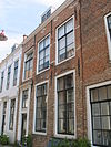 Huis met geverfde rechte gevel, muurankers en ontlastingsbogen