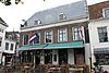 Huis met aan de pottenmarkt brede zijgevel met eenvoudige consoles in de lijst, en aan de zijde van de lange viele ingezwenkte lijstgevel met datering 1721
