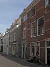 Dwarshuis met geverfde gevel en gootlijst op klossen