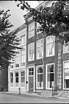 Huis met rechte gevel en van pirons voorzien schilddak aan de straat