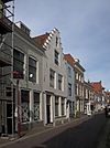 Huis met gepleisterd trapgevel, overkragend op pui