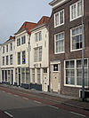 Huis met lijstgevel, aan de hoeken afgeschuind, overkragend op de pui