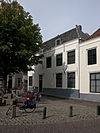 Pand met gepleisterde langsgevel, aan de varkensmarkt, en een afgeknotte puntgevel met puilijst aan de zijde van de gortstraat
