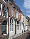 Huis met pilastergevel. Benedenstuk vernieuwd en gepleisterd. Verdieping met jonische pilasters. In de kroonlijst datumsteen met jaartal 1646. Voordeuromlijsting. Stoep
