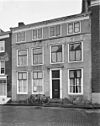 Huis met in blokken gepleisterde rechte gevel