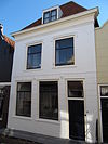 Huis met schilddak en lijstgevel, gepleisterd