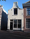 Huis met gepleisterde klokgevel, winkelpui