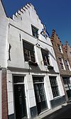 Pand met gecementeerde trapgevel. De treden afgedekt met natuurstenen platen. Waterlijsten