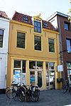 Huis met gepleisterde rechte gevel. Dakluik met hijsbalk. Kelderlichten