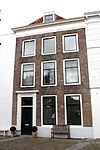 Huis met lijstgevel. Dakkapel. Eenvoudige voordeuromlijsting